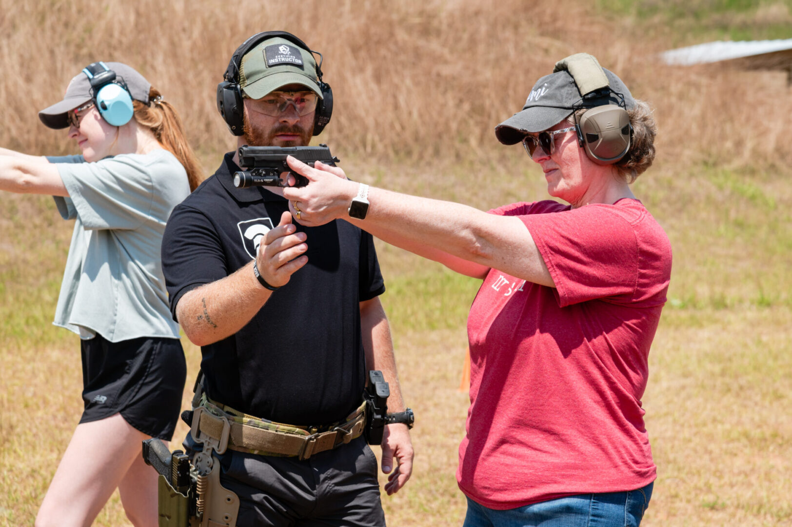 A woman pointing at something while standing next to a man.